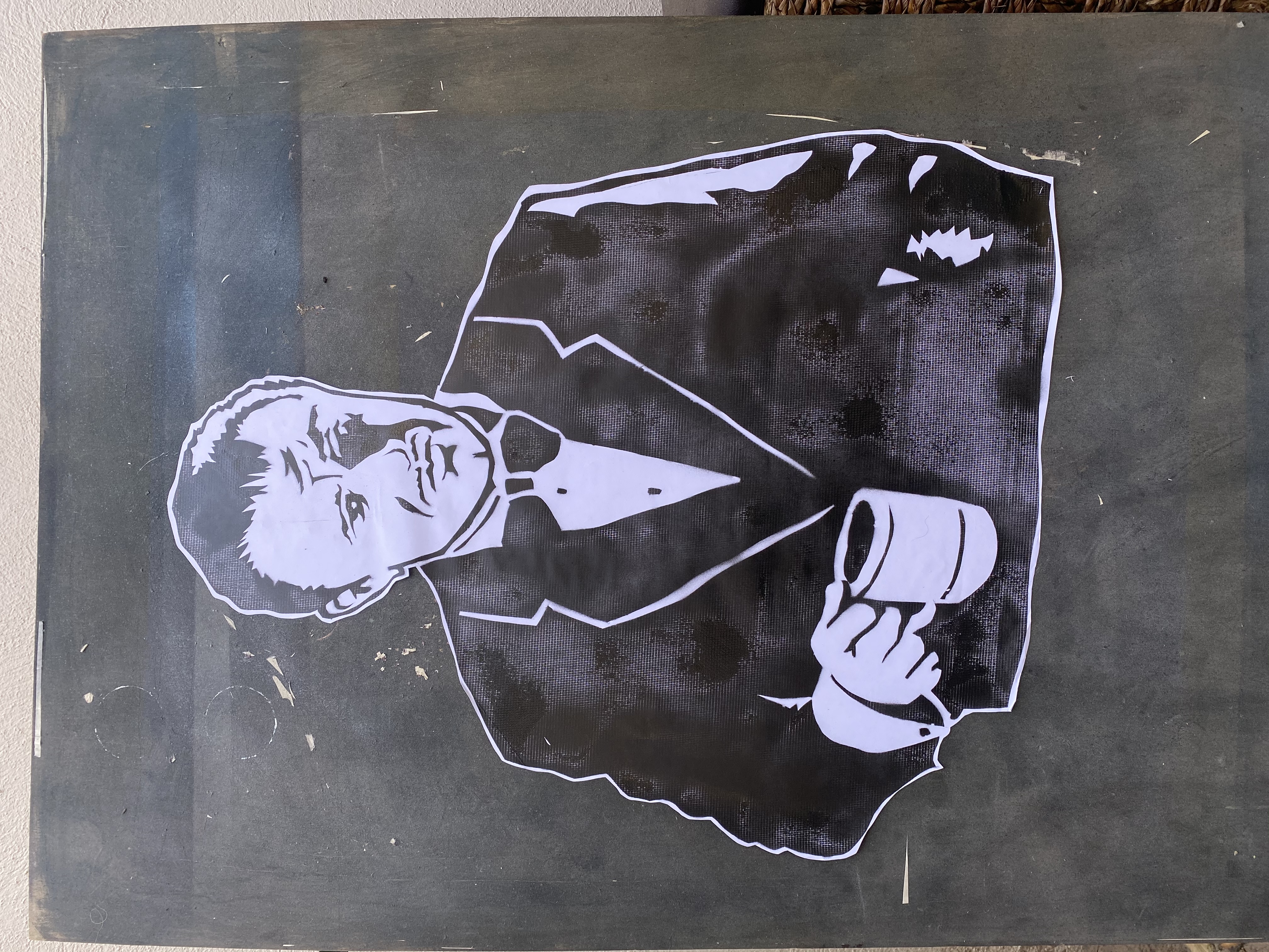 Stencil portrait of a man in a suit holding a mug